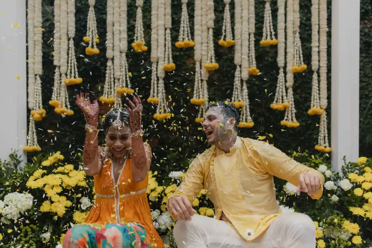 A beautiful flower shower at the haldi ceremony celebrates a Hindu wedding in Dubai, enveloping the bride and groom in blossoms.