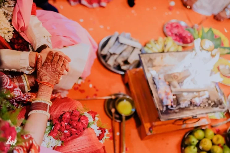 The bride and groom hold hands tightly as they circle the sacred fire, symbolizing their eternal bond on their wedding day.