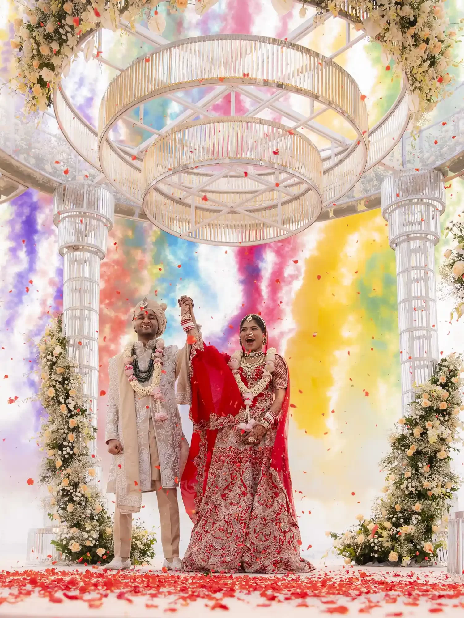 Wedding photography in Dubai Beach captures a joyful moment as the couple celebrates with varmala and a beautiful flower shower and color blast.