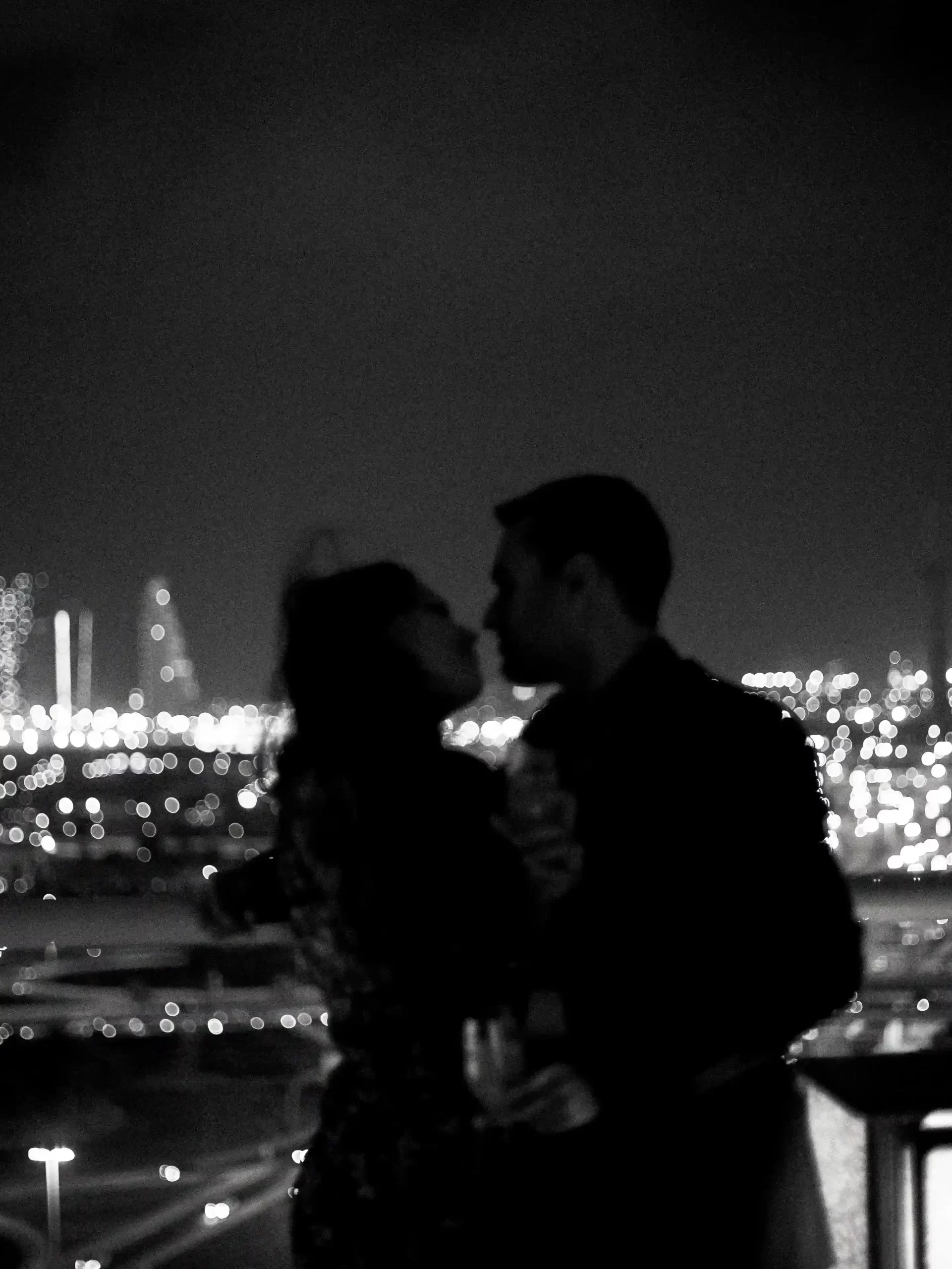 Couple posing in a black and white photo, embracing with a beautiful city view of Dubai in the background for their pre wedding shoot.