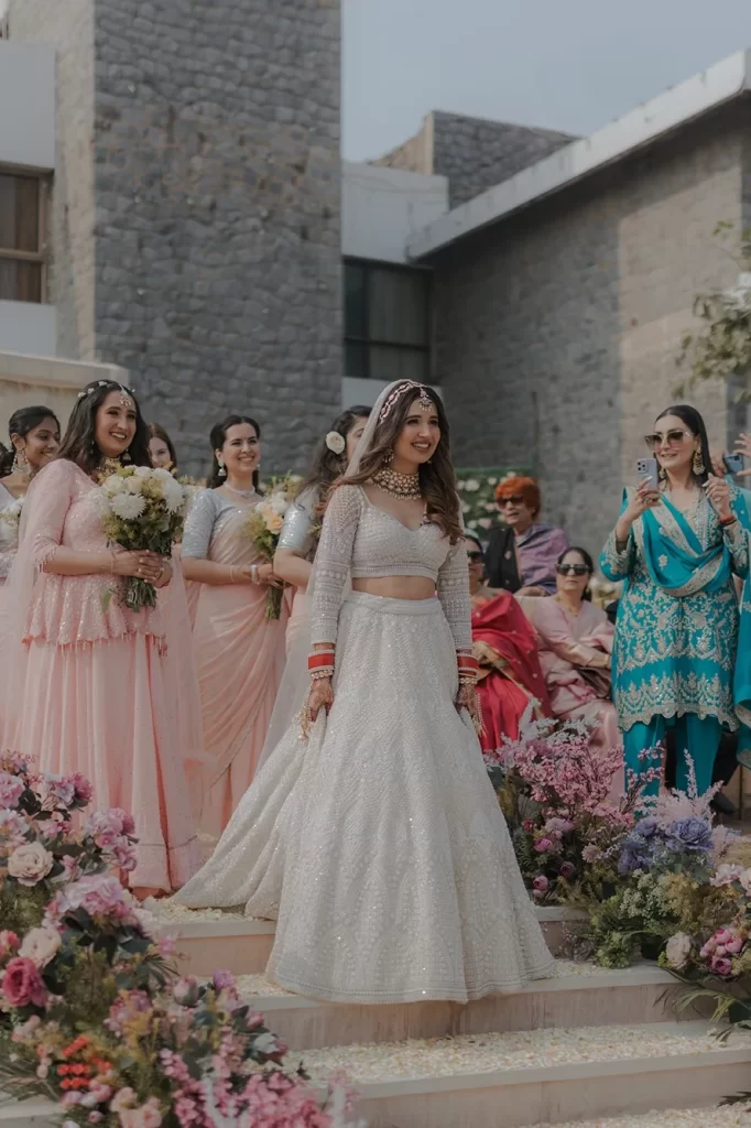 A radiant bride walks alongside her bridesmaid, capturing a beautiful moment in elegant wedding photography in Dubai.